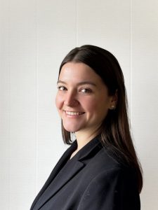 Indigenous woman with long dark hair wearing a black blazer on a white background